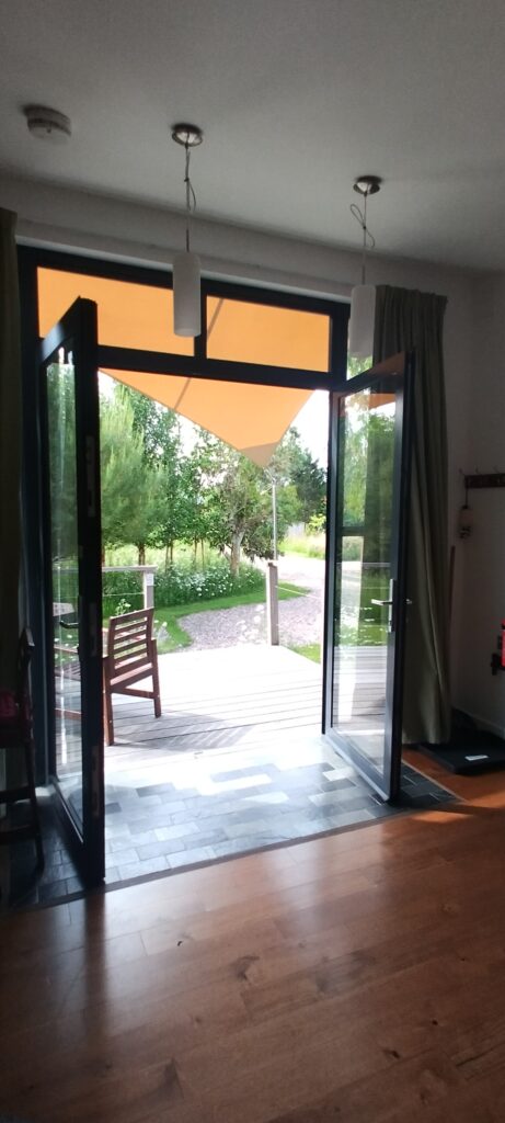 Lodge 1 decking with trees and flower meadows beyond